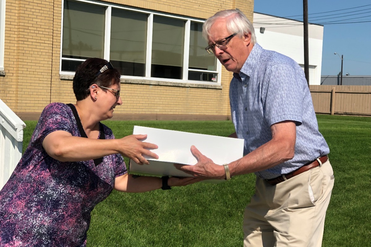 Jerry handing a bakery box to customer