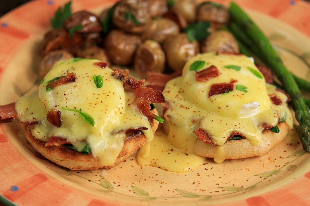 Eggs Benedict gluten-free on colourful plate with asparagus