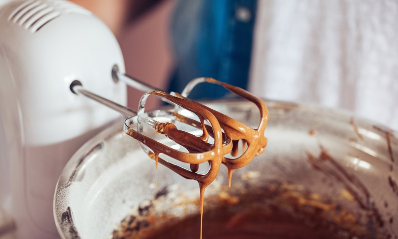 Whisks over bowl with chocolate cake batter