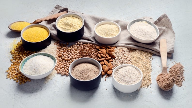 Gluten-free flours selection in bowls and wooden spoons