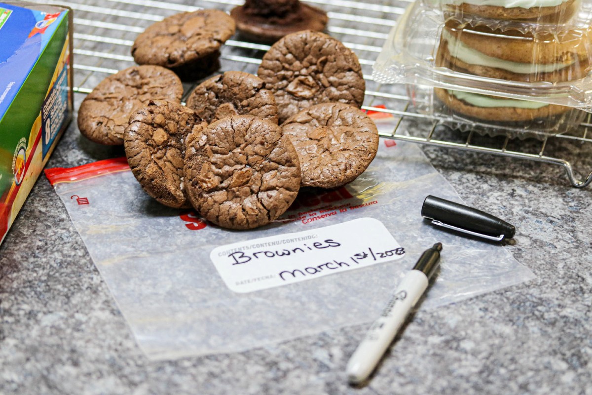 Gluten-free brownies in background of freezer bag with product and date written on it