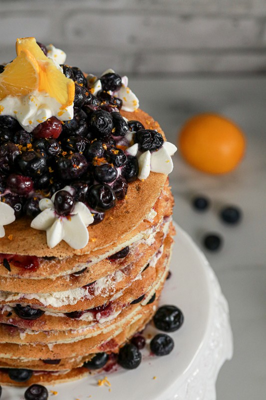 Gluten-free Lemon Blueberry Torte on white stand on white table