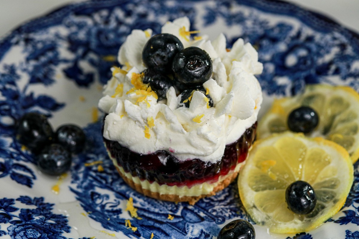 Gluten-free Lemon Blueberry mini cheesecakes on top tiers of a glass cake stand