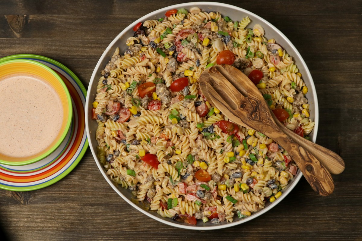 Mexican Pasta Salad in brightly coloured bowl on wooden board gluten-free