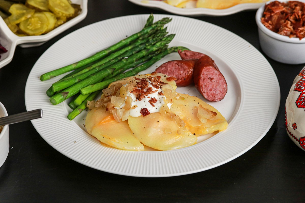 Gluten-free Cheddar Pierogies on dish surrounded by Ukrainian plates and casserole dishes