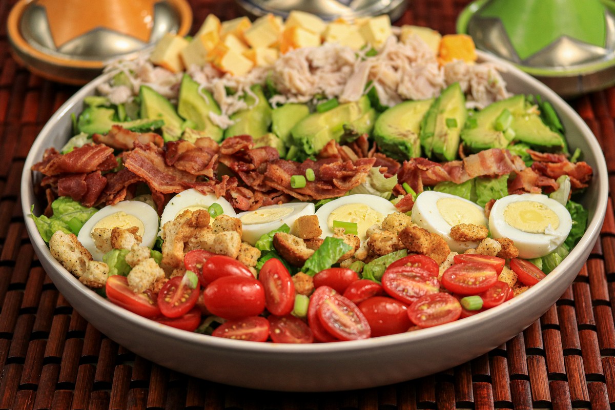 Gluten-free Cobb salad ingredients in a grey bowl eggs tomatoes turkey bacon 