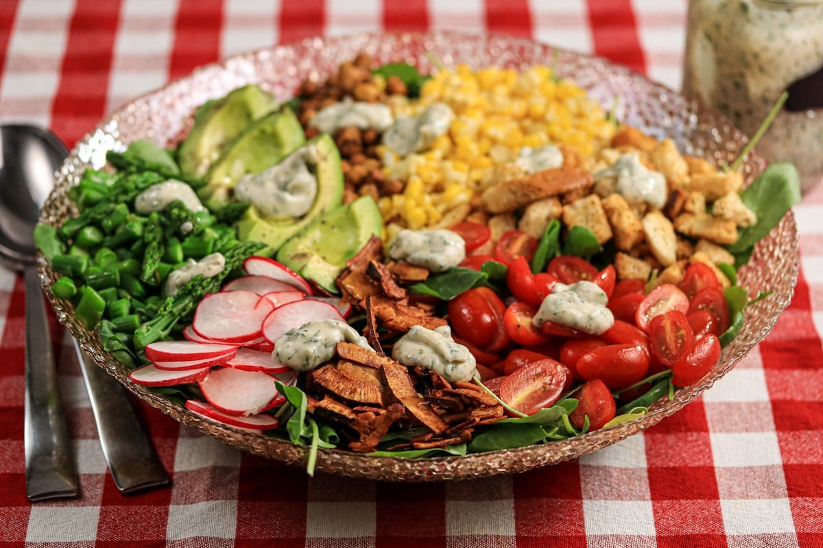 Gluten-free croutons on a vegan cobb salad, corn, tomatoes, coconut chips, avocado