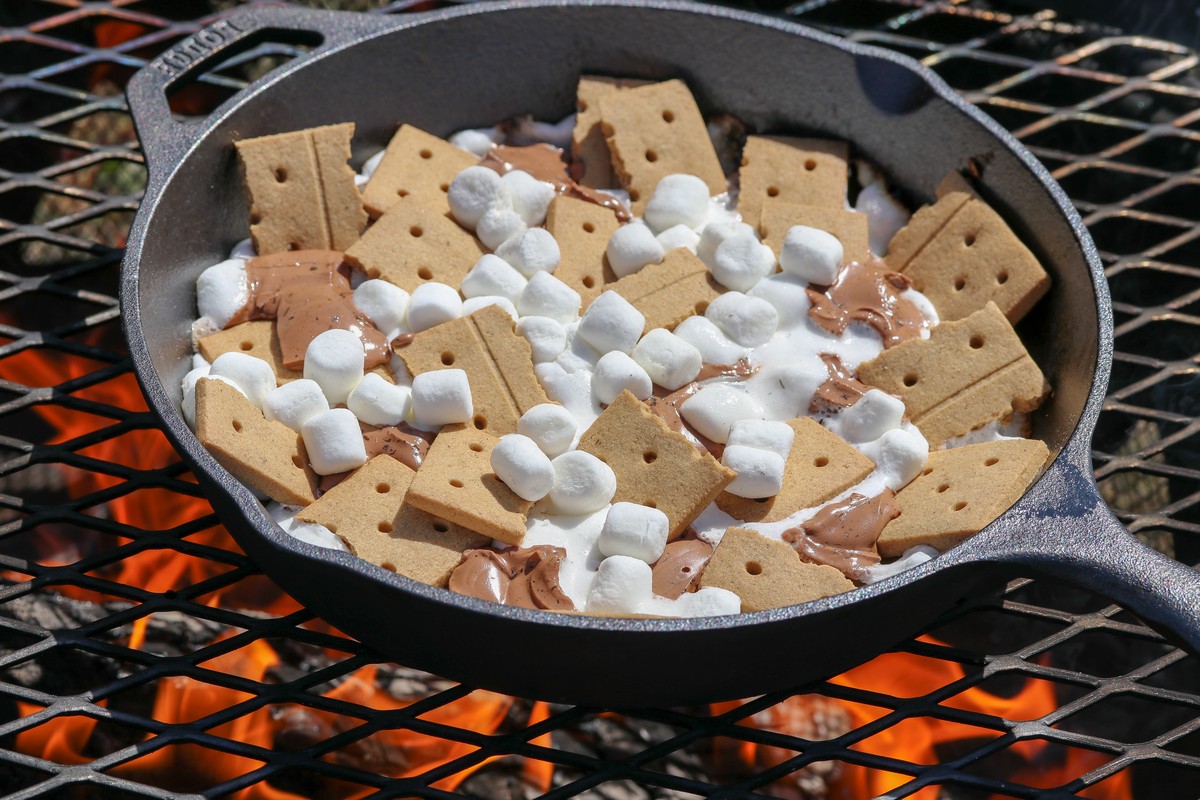 Smores in a cast iron skillet on coals on a fire