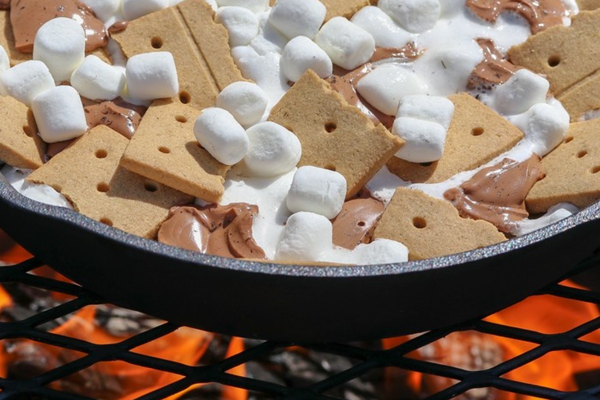 Smores Nachos in cast iron skillet on grille of coals