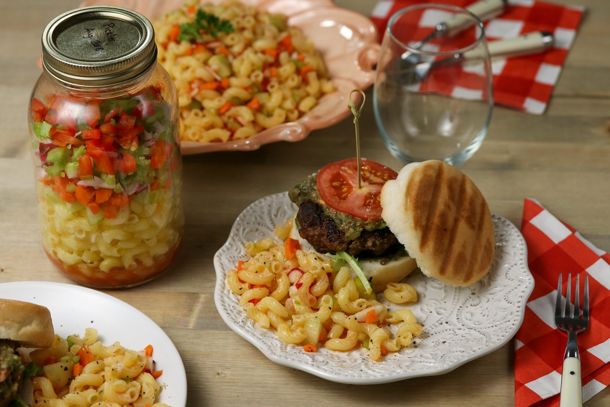 gluten free pasta salad in pink flowery plate & glass mason jar on wooden table