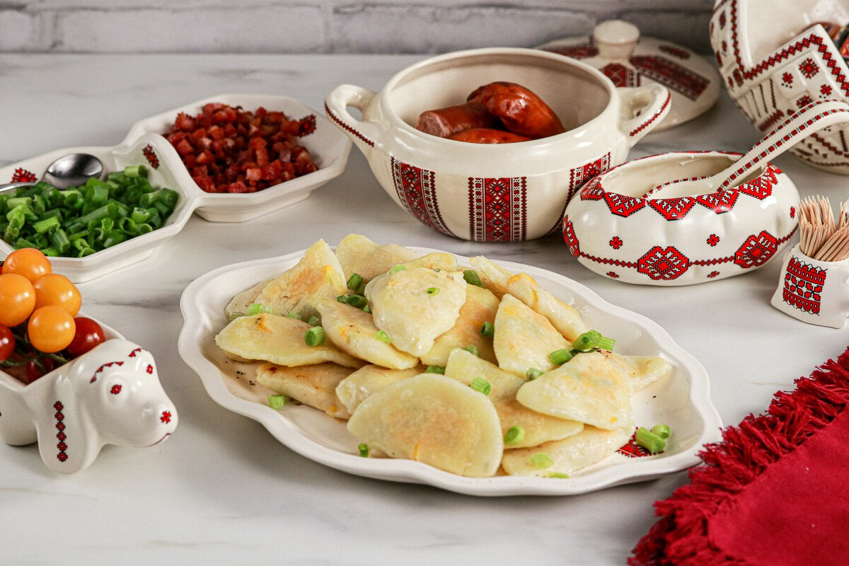 Gluten & Dairy Free Pierogi on Ukrainian serving dish surrounded by Ukrainian dishes